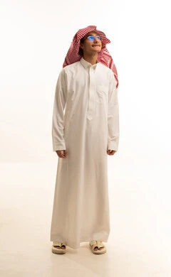 A portrait of a smiling Saudi Arabian Gulf man wearing traditional attire and a ghutrah, standing with gestures of joy and happiness, standing confidently and upright, elegance and attention to appearance, with a white background.