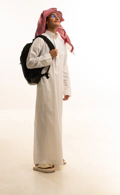 التعليم فى المملكة، الاستعداد للعام الجامعي الجديد، الجامعات والكليات الأكاديمية،  بورتريه لرجل عربي خليجي سعودي يرتدي الزي التقليدي  والشماغ  وحقيبة الظهر يقوم بمتابعة الدروس اليومية، صورة لكامل الجسم، خلفية بيضاء