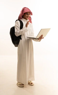 Educational materials and curricula in the Kingdom, the concept of distance education, following lectures through advanced educational platforms, a portrait of a Saudi Arabian Gulf man wearing traditional attire and a ghutrah, with a backpack and a laptop, full-body image, white background.