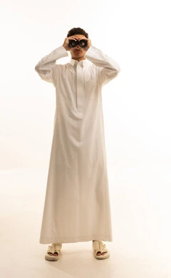 Seeing distant things through a telescope with gestures of amazement and joy, future planning for goals and ambitions, a portrait of a Saudi Arabian Gulf man wearing traditional attire looking through a binocular, a love for exploration and adventure, white background.