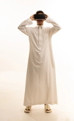 Spending enjoyable time playing video games, simulating the fantasy world, wearing virtual reality glasses, using modern technological devices, a portrait of an Arab Gulf Saudi man wearing traditional attire and wearing 3D VR glasses, white background. Spending enjoyable time playing video games, simulating the fantasy world, wearing virtual reality glasses, using modern technological devices, a portrait of an Arab Gulf Saudi man wearing traditional attire and wearing 3D VR glasses, white background.