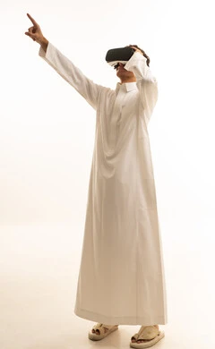 ارتداء نظارات الواقع الافتراضي, محاكاة العالم الخيالي,استخدام الأجهزة التقنية الحديثة,بورتريه لرجل عربي خليجي سعودي يرتدي الزي التقليدي يضع نظارة الفي ار ثلاثية الأبعاد، قضاء وقت ممتع باللعب في العاب الفيديو ، خلفية بيضاء
