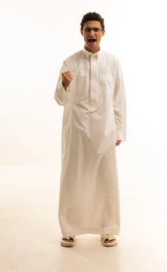 إيماءات الفوز والانتصار, بورتريه لرجل عربي خليجي سعودي مبتسم يرتدي الثوب التقليدي يرفع يديه بتفاعل وحماس, الاندماج بتشجيع فريق كرة القدم, صورة الجسم بالطول الكامل, خلفية بيضاء