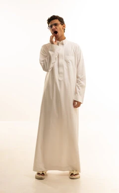 مفهوم تسوس الأضراس, بورتريه لرجل عربي خليجي سعودي يرتدي الثوب التقليدي يضع يده على وجهه بإيماءات الألم و وجع الأسنان، الإنتفاخ والإلتهاب بالفم واللثة، ضرورة الذهاب للطبيب والحصول على العلاج، صورة الجسم بالطول الكامل، خلفية بيضاء