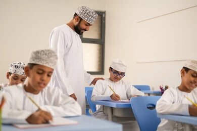 حل الامتحان بانتباه وتركيز، الإستعداد للعام الدراسي الجديد، التعليم في سلطنة عمان ، العودة إلى المدارس، مجموعه من الطلاب عربيين خليجيين عمانيين يجلسون في مقاعدهم برفقة معلمهم