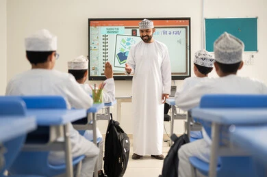 تنشيط العلوم وتنمية القدرات الابتكارية، متابعة مجموعة من الطلاب داخل الفصل، معلم عربي خليجي عماني يرتدي الدشداشه والكمه يشرح لطلابه في بيئه مدرسيه تعليميه متطوره، نظام التعليم الحديث، جودة التعلم في المدارس الأكاديميه