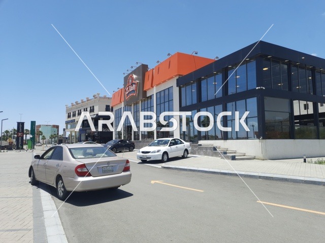 المباني والمحلات التجارية، الطرقات الاسفلتية المعبدة في الأماكن الجبلية في وقت النهار، طريق معبد في منطقة الباحة، أعمدة الإنارة الطرقية، حركة مرور السيارات في الشوارع
