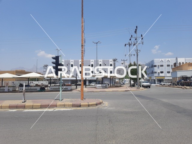المباني والمحلات التجارية، الطرقات الاسفلتية المعبدة في الأماكن الجبلية في وقت النهار، طريق معبد في منطقة الباحة، أعمدة الإنارة الطرقية، حركة مرور السيارات في الشوارع