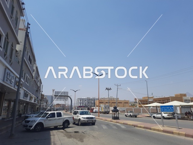 المباني والمحلات التجارية، الطرقات الاسفلتية المعبدة في الأماكن الجبلية في وقت النهار، طريق معبد في منطقة الباحة، أعمدة الإنارة الطرقية، حركة مرور السيارات في الشوارع