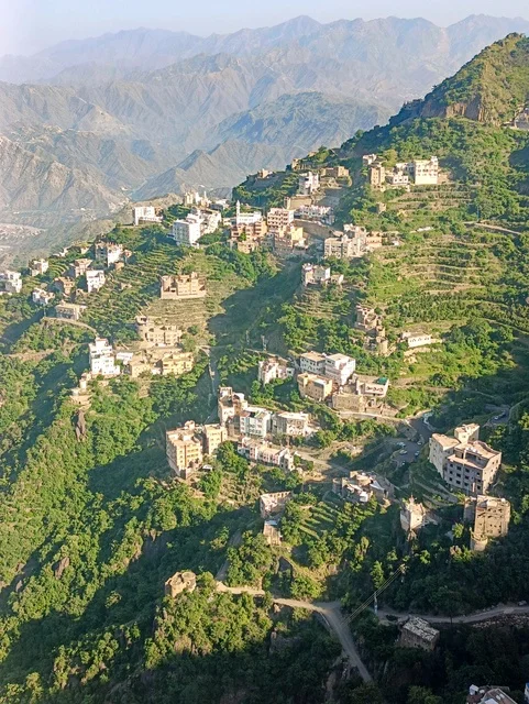 مكان ومنطقة سياحية طبيعية، البيوت القديمة الشعبية على جبال فيفاء في جازان جنوب المملكة العربية السعودية، القمم والمرتفعات الصخرية في النهار، الأشجار والنباتات ومساحات الطبيعة الخضراء، المدرجات الزراعية على السفوح الجبلية