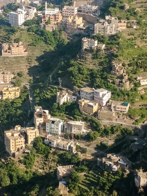 البيوت القديمة الشعبية على جبال فيفاء في جازان جنوب المملكة العربية السعودية، القمم والمرتفعات الصخرية في النهار، مكان ومنطقة سياحية طبيعية، الأشجار والنباتات ومساحات الطبيعة الخضراء، المدرجات الزراعية على السفوح الجبلية