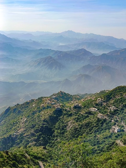 منظر طبيعي  في محافظة فيفاء بمنطقة جازان جنوب المملكة العربية السعودية ، المنازل والبيوت القديمة ،معالم وأماكن سياحية طبيعية ، المدرجات الزراعية الخضراء والاشجار على القمم والمرتفعات الجبلية، خلفية الطبيعة