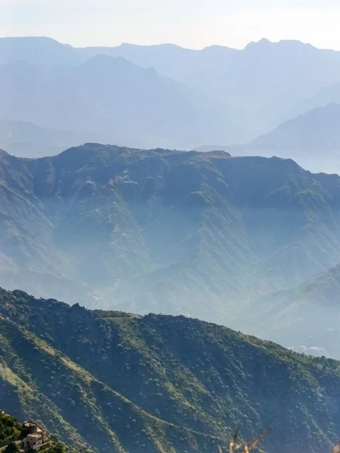 A place and natural tourist area, the landscapes of nature in the province of Faifa in the Jazan region in the south of the Kingdom of Saudi Arabia, the old houses and buildings, the green agricultural terraces, and the trees on the peaks and mountain heights, a natural backdrop.