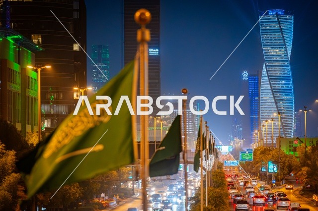 لوحات طرقية زرقاء، علم المملكة راية التوحيد الخضراء، الفن الهندسي المعماري لبرج مضاء في مدينة الرياض في وقت الليل، معالم تجارية واقتصادية وسياحية مشهورة في العاصمة، الفن الهندسي المعماري للمنشآت، النمو والتطور العمراني على الطراز الحديث والمتطور للأبراج