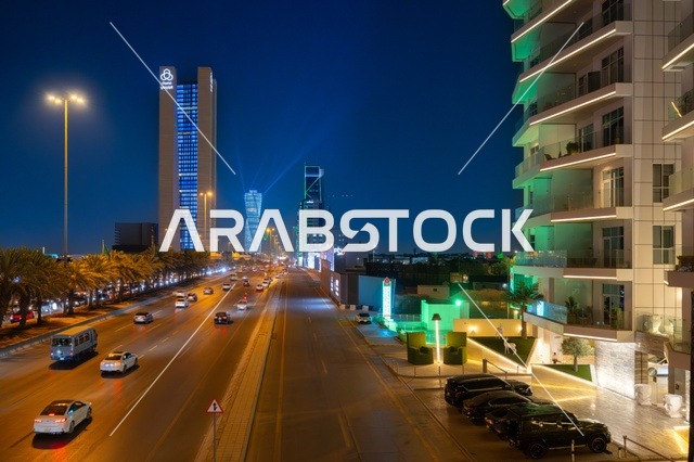 Famous landmarks and commercial, economic, and tourist buildings in the capital, the architectural engineering art of the facilities, urban growth and development in the modern and advanced style of towers and skyscrapers in the Kingdom of Saudi Arabia, the architectural engineering art of a lit tower in the city of Riyadh at night.