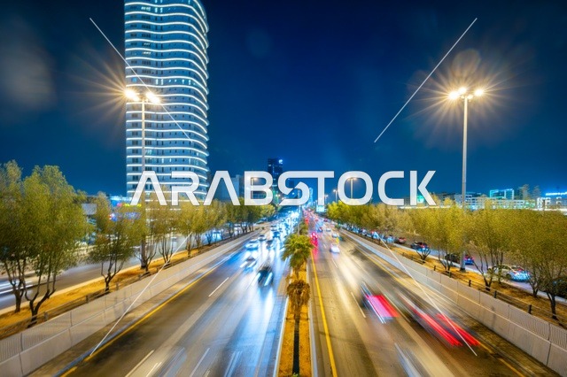 حركة المرور في شارع كبير،  الفن الهندسي المعماري لبرج مضاء في مدينة الرياض في وقت الليل، معالم تجارية واقتصادية وسياحية مشهورة في العاصمة، الفن الهندسي المعماري للمنشآت، النمو والتطور العمراني على الطراز الحديث والمتطور للأبراج