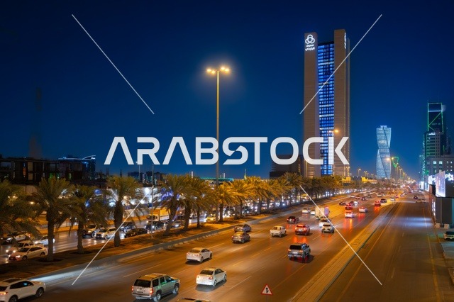 Famous landmarks and commercial, economic, and tourist buildings in the capital, the architectural engineering art of the facilities, urban growth and development in the modern and advanced style of towers and skyscrapers in the Kingdom of Saudi Arabia, the architectural engineering art of a lit tower in the city of Riyadh at night.