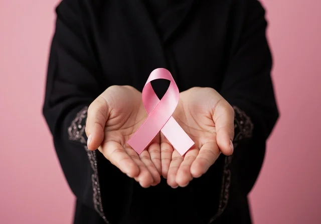 بورتريه مقرب لإمرأة عربية خليجية سعودية ترتدي الحجاب والعباءة السوداء وتحمل الشريط الوردي، حملة توعية للكشف المبكر عن سرطان الثدي، اليوم العالمي للتوعية والكشف المبكر، تحدي الأمراض الخبيثة، رمز الحملة العالمية،