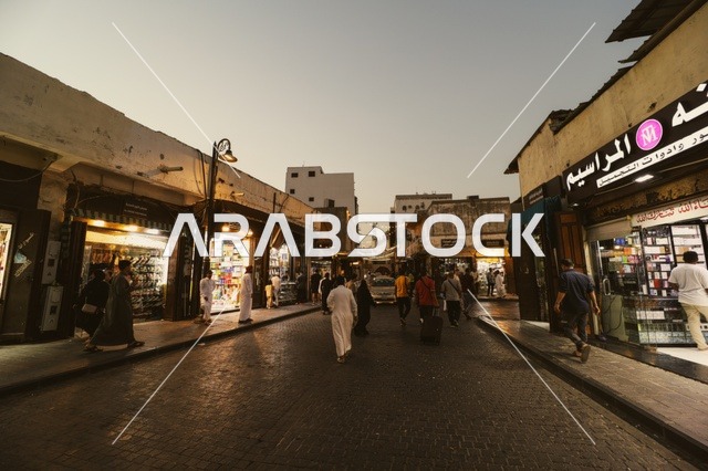 رجال في سوق شعبي يرتدون الزي التقليدي في جدة، المعالم التاريخية في حي البلد، أماكن سياحية تراثية شعبية في المملكة العربية السعودية، الرواشين القديمه في المدينة التاريخية في جدة،  تصميم معماري عربي و إسلامي قديم،  مناطق جذب واستقطاب السياح