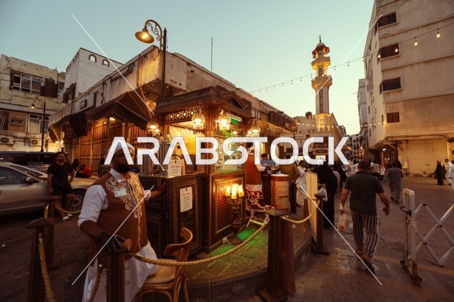 رجال في سوق شعبي يرتدون الزي التقليدي في جدة، المعالم التاريخية في حي البلد، أماكن سياحية تراثية شعبية في المملكة العربية السعودية، الرواشين القديمه في المدينة التاريخية في جدة،  تصميم معماري عربي و إسلامي قديم،  مناطق جذب واستقطاب السياح