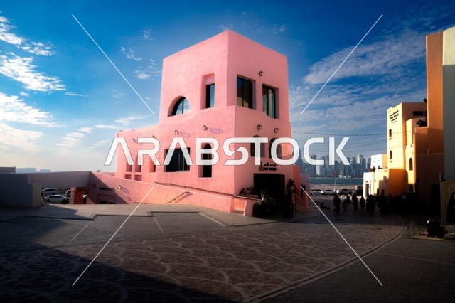 مركز جذب السياح من شتى أنحاء العالم، تصاميم تعكس التراث والتاريخ القطري بألوان مميزة، صورة مقربة لمبنى في ميناء الدوحة القديم في قطر، تعزيز صناعة السياحة البحرية، الفن الهندسي المعماري للمباني والفنادق والشاليهات على شاطئ البحر