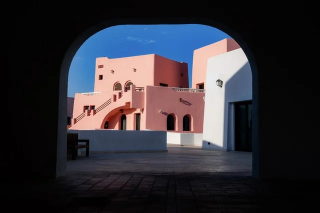 مركز جذب السياح من شتى أنحاء العالم، تصاميم تعكس التراث والتاريخ القطري بألوان مميزة، صورة مقربة لمبنى في ميناء الدوحة القديم في قطر، تعزيز صناعة السياحة البحرية، الفن الهندسي المعماري للمباني والفنادق والشاليهات على شاطئ البحر