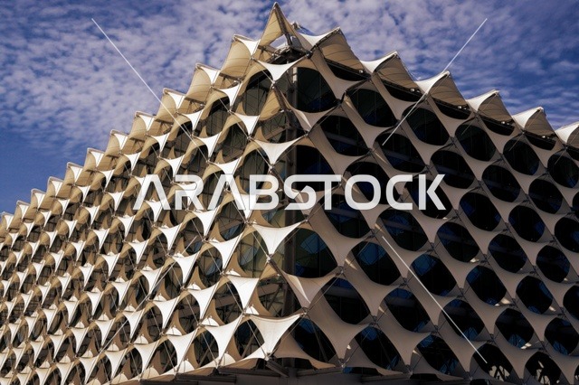 The architectural engineering art of the exterior of King Fahd National Library in Riyadh, green trees and plants, national libraries in the Kingdom of Saudi Arabia, famous cultural landmarks of Riyadh, a close-up image of the architectural engineering art of the exterior of King Fahd Library, tourist attractions in Saudi Arabia.