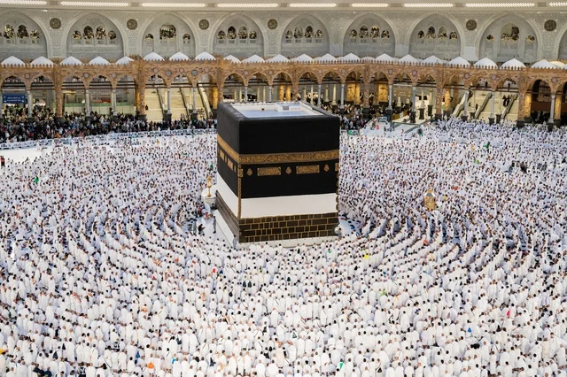 Performing the rituals of Hajj and Umrah, worship and drawing closer to God, the qibla of Islam and Muslims, the circumambulation of pilgrims and Umrah performers around the Holy Kaaba in Mecca during the day, the minarets surrounding the sanctuary, the House of God in the Sacred Mosque in the Holy City of Mecca in the Kingdom of Saudi Arabia.