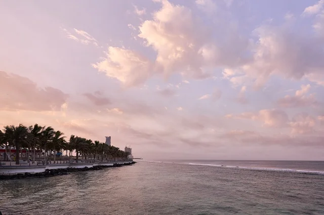 السماء الصافيه في وقت الغروب، الكورنيش المطل على ساحل البحر الأحمر, مناطق جذب الزوار إلى مدينة جدة الساحلية, معالم وأماكن سياحية مشهورة, الواجهة البحرية في المملكة العربية السعودية, المناظر الطبيعية المائية، الاهتمام بزراعة الأشجار