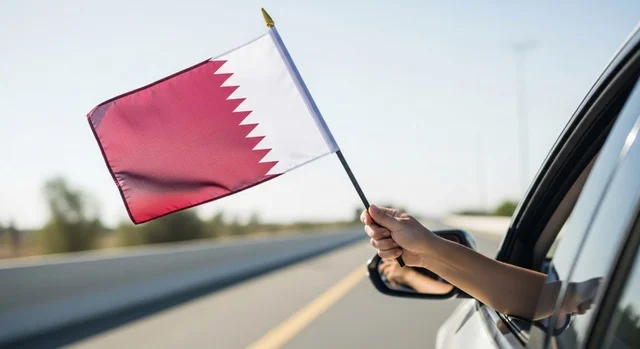 إحياء ذكرى تأسيس الدولة، الاحتفال باليوم الوطني القطري 18 ديسمبر، صورة مقربة ليد رجل عربي خليجي قطري داخل سيارة يحمل علم قطر إلى الخارج بايماءات الفخروالاعتزاز، رموز وثقافات وطنية, حب الوطن والانتماء إليه، تعبير عن الانتماء والهوية القطرية