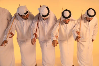 الحفاظ على التراث الشعبي في المناسبات الوطنية والاجتماعية ،إيقاعات متناغمة وحركات جماعية تعكس روح الوحدة والاعتزاز بالهوية الوطنية،مجموعة من الرجال العرب الخليجيين الإماراتيين يرتدون الكندورة والغترة البيضاء يؤدون رقصة العيالة الشعبية بعصا الخيزران، أجواء تراثية تعبّر عن الفخر بالموروث الثقافي الإماراتي، الحفاظ على التراث الشعبي في المناسبات الوطنية والاجتماعية. الحفاظ على التراث الشعبي في المناسبات الوطنية والاجتماعية ،إيقاعات متناغمة وحركات جماعية تعكس روح الوحدة والاعتزاز بالهوية الوطنية،مجموعة من الرجال العرب الخليجيين الإماراتيين يرتدون الكندورة والغترة البيضاء يؤدون رقصة العيالة الشعبية بعصا الخيزران، أجواء تراثية تعبّر عن الفخر بالموروث الثقافي الإماراتي، الحفاظ على التراث الشعبي في المناسبات الوطنية والاجتماعية.