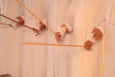 الاحتفال بالمناسبات الوطنية والتراثية، أداء الفنون الشعبية الإماراتية، بورترية لمجموعة من الرجال العرب الخليجيين الإماراتيين يرتدون الكندورة والغترة يقومون بعرض رقصة العيالة التراثية، إيماءات السرور والفخر بالهوية الوطنية، الحفاظ على الموروث الثقافي والعادات الأصيلة