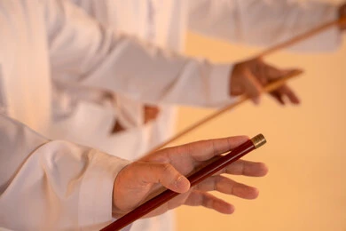 Expressions of pride and honor, celebrating national and heritage occasions, performing Emirati folk arts, a close portrait of a group of Emirati Gulf Arab men wearing the kandura and ghutrah performing the traditional Ayala dance, gestures of joy and pride in national identity, preserving cultural heritage and authentic traditions.