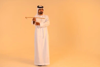 Celebrating the Emirati folk heritage, a portrait of an Emirati Gulf Arab man wearing the kandura and ghutrah performing the Ayala dance with a wooden stick, gestures of pride and honor in national identity, participation in heritage events and national occasions, preserving the authentic cultural heritage.