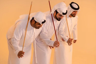 بورترية لمجموعة من الرجال العرب الخليجيين الإماراتيين يرتدون الكندورة والغترة  يقومون بعرض رقصة العيالة التراثية، إيماءات السرور والفخر بالهوية الوطنية، الحفاظ على الموروث الثقافي والعادات الأصيلة،الاحتفال بالمناسبات الوطنية والتراثية، أداء الفنون الشعبية الإماراتية