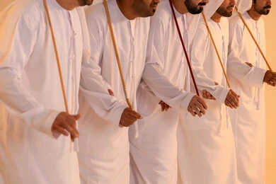 Celebratory atmosphere filled with pride and honor, manifestations of joy and celebration of the authentic Emirati heritage, a portrait of a group of Emirati Gulf Arab men wearing the kandura and ghutrah performing the traditional Ayala dance with wooden sticks, embodying national identity and belonging, preserving popular customs and traditions during national occasions. Celebratory atmosphere filled with pride and honor, manifestations of joy and celebration of the authentic Emirati heritage, a portrait of a group of Emirati Gulf Arab men wearing the kandura and ghutrah performing the traditional Ayala dance with wooden sticks, embodying national identity and belonging, preserving popular customs and traditions during national occasions.