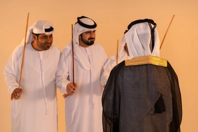 Expressions of joy and celebration of the authentic Emirati heritage, a portrait of a group of Emirati Gulf Arab men wearing the kandura and ghutrah performing the traditional Ayala dance with wooden sticks, embodying national identity and belonging, preserving customs and traditions during national occasions, a festive atmosphere filled with pride and honor.