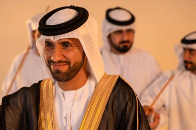 Performance of Emirati folk arts, celebrating national and heritage occasions, a portrait of a group of Emirati Gulf Arab men wearing traditional attire performing the traditional Ayala dance, gestures of joy and pride in national identity, preserving cultural heritage and authentic customs.