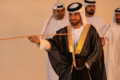 Celebrating national and heritage occasions, performing Emirati folk arts, a portrait of a group of Emirati Gulf Arab men wearing traditional attire performing the heritage Ayala dance, gestures of joy and pride in national identity, preserving cultural heritage and authentic customs. Celebrating national and heritage occasions, performing Emirati folk arts, a portrait of a group of Emirati Gulf Arab men wearing traditional attire performing the heritage Ayala dance, gestures of joy and pride in national identity, preserving cultural heritage and authentic customs.