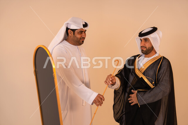 Preparation for official occasions and national celebrations, manifestations of authenticity and elegance, a portrait of an Emirati Gulf Arab man wearing a black bisht embroidered with gold with the help of his friend, the concept of elegance and attention to appearance, preparation for national celebrations.