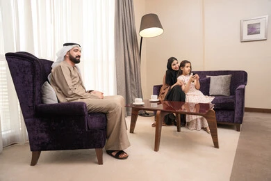 تعابير الفرح والسرور، برنامج كوميدي ترفيهي، قضاء وقت الفراغ بالتسلية والترفيه,عائلة عربيه خليجيه اماراتية ترتدي الزي التقليدي تجلس فى غرفه المعيشة يقومون بمشاهدة الفلم والمسلسل