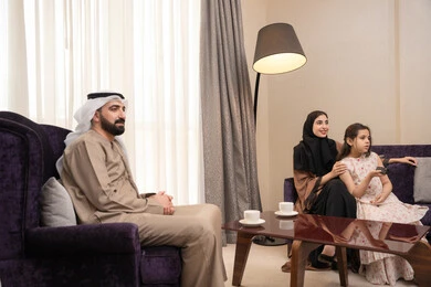 برنامج كوميدي ترفيهي، قضاء وقت الفراغ بالتسلية والترفيه,عائلة عربيه خليجيه اماراتية ترتدي الزي التقليدي تجلس فى غرفه المعيشة يقومون بمشاهدة الفلم والمسلسل, تعابير الفرح والسرور