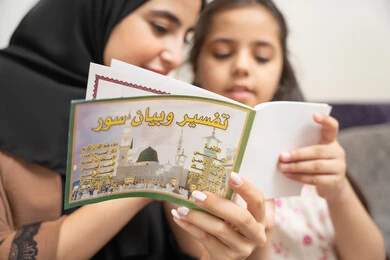 تعليم الاولاد على التثقيف والمطالعة، مفهوم السعاده الأسرية وإهتمام الأم بالأبناء، سيده سعودية تقوم بقضاء وقت ممتع مع الأبناء، صورة مقربة لام عربية خليجيه اماراتية ترتدي العباءة السوداء تقوم بقراءة تفسير و بيان السور برفقة ابنتها، العبادة والتقرب الى الله