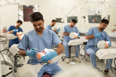 معدات متخصصة لعلاج الأسنان، معالجة التسوس وتركيب الحشوات، مجموعة من الطلاب الجامعيين بكلية الأسنان يرتدون القفازات يقومون بفحص الأسنان على مجسم