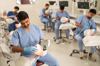 The therapeutic methods used for oral care, the use of dental equipment and tools, the treatment of cavities and the placement of fillings, a group of university students in the dental college wearing gloves examining teeth on a model.