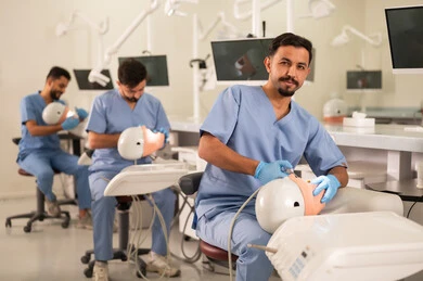 استخدام أدوات وقاية وعلاج الأسنان، طرق علاجية للعناية بالأسنان، معالجة التسوس وتركيب الحشوات، مجموعة من الطلاب الجامعيين بكلية الأسنان يرتدون القفازات يقومون بفحص الأسنان على مجسم استخدام أدوات وقاية وعلاج الأسنان، طرق علاجية للعناية بالأسنان، معالجة التسوس وتركيب الحشوات، مجموعة من الطلاب الجامعيين بكلية الأسنان يرتدون القفازات يقومون بفحص الأسنان على مجسم