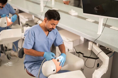 علاج تجاويف الأسنان المصابة بالنخر، طالب جامعي بكلية الأسنان يرتدي القفازات يقوم بفحص مجسم به طاقم أسنان، مفهوم التدريب العملي، المعدات والادوات اللازمة لإجراء الفحوصات, الأساليب العلاجية المتبعة للعناية بالفم