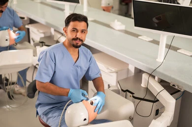 إزالة التلف الناتج عن التسوس السني، طالب جامعي بكلية الأسنان يرتدي القفازات يقوم بفحص مجسم به طاقم أسنان، مفهوم التدريب العملي، المعدات والادوات اللازمة لإجراء الفحوصات, الأساليب العلاجية المتبعة للعناية بالفم