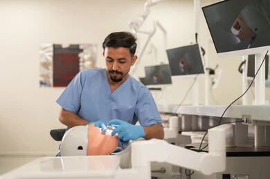 ترميم الأسنان باستخدام الحشوات، طالب جامعي بكلية الأسنان يرتدي القفازات يقوم بفحص مجسم به طاقم أسنان، مفهوم التدريب العملي، المعدات والادوات اللازمة لإجراء الفحوصات, الأساليب العلاجية المتبعة للعناية بالفم