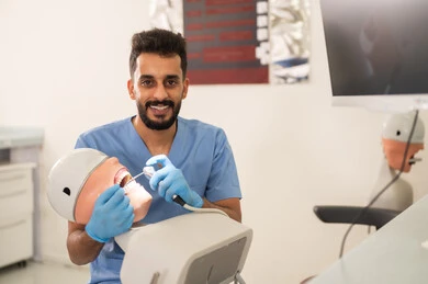 علاج الأسنان المتآكلة، طالب جامعي بكلية الأسنان يرتدي القفازات يقوم بفحص مجسم به طاقم أسنان، مفهوم التدريب العملي، المعدات والادوات اللازمة لإجراء الفحوصات, الأساليب العلاجية المتبعة للعناية بالفم